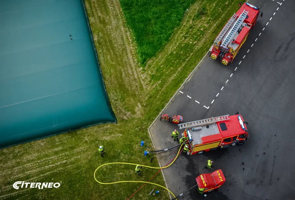 Des pompiers se raccordant aux prises déportées d'une citerne souple CITERNEO pour la défense incendie